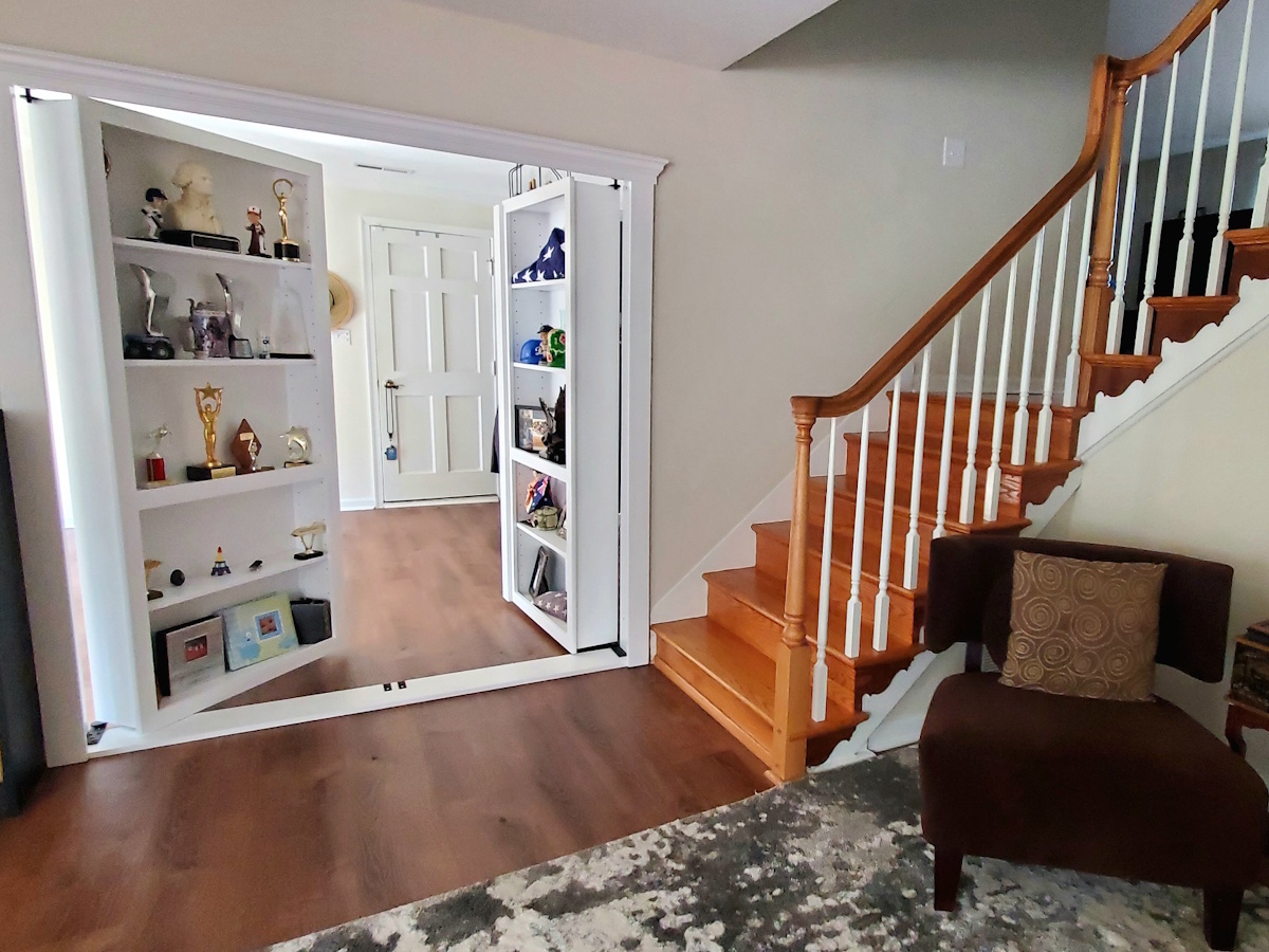 Hidden bookcase door installed in a residential living space with wood flooring